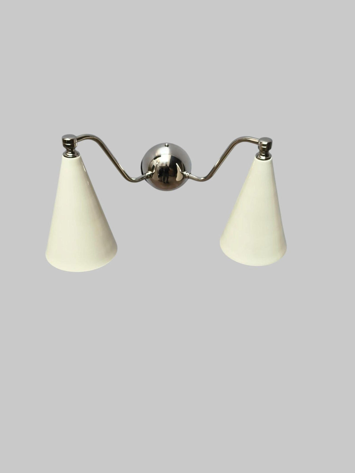 Handmade brass dual cone wall sconce with minimalist design, featuring polished body and ivory cone shades.