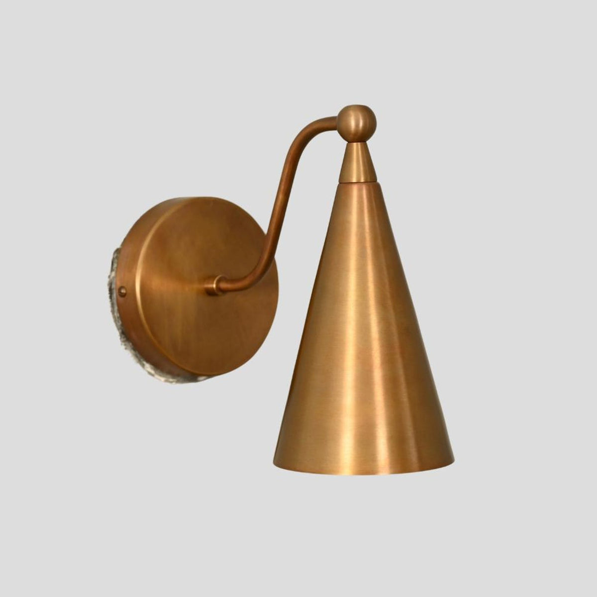 Handmade brass wall sconce with sleek cone shade, minimalist and durable wall-mounted lighting fixture.