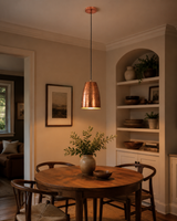 Hudson Hammered Copper Bell Pendant Light installed above a modern dining table in a warm contemporary dining room.
