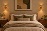 Decorative perforated brass wall light producing glowing pinpoints and warm light across a modern interior wall