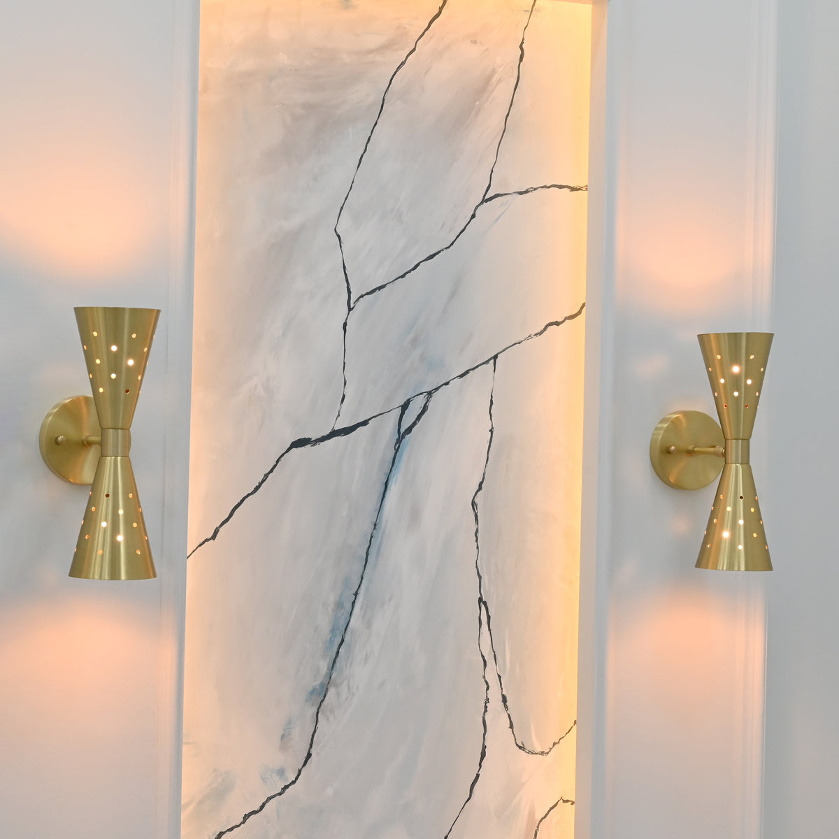 Solid brass hourglass wall light with opposing cone shades, round backplate and decorative perforations