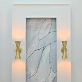 Close view of Ibiza wall sconce showing brushed brass surface, perforated shades and sculptural double cone form