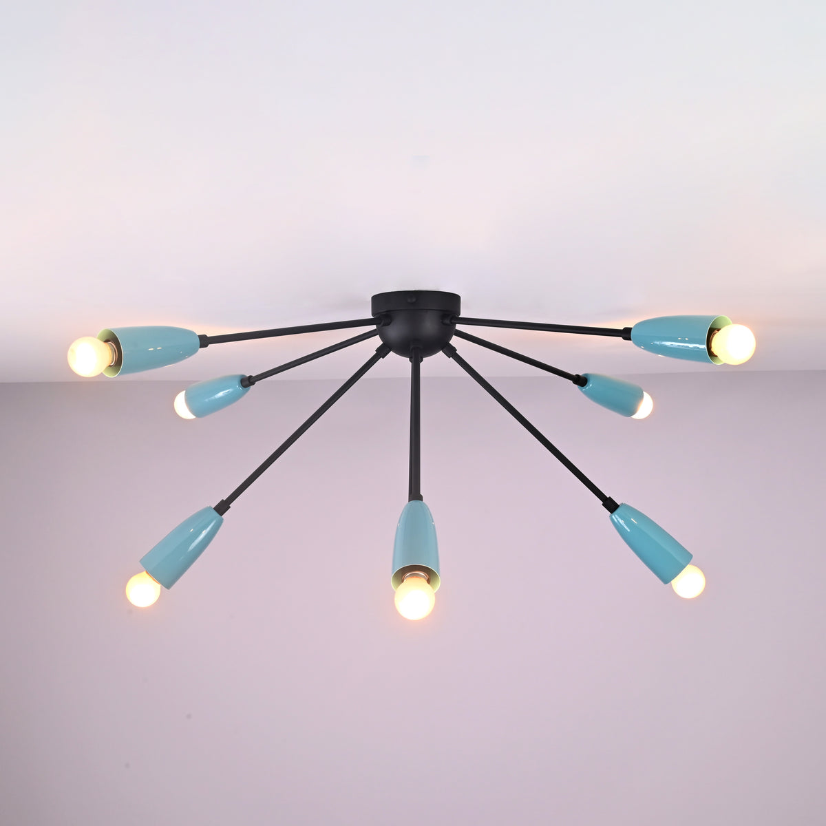 Angled ceiling view of industrial orbit brass flush mount light with eight radiating arms