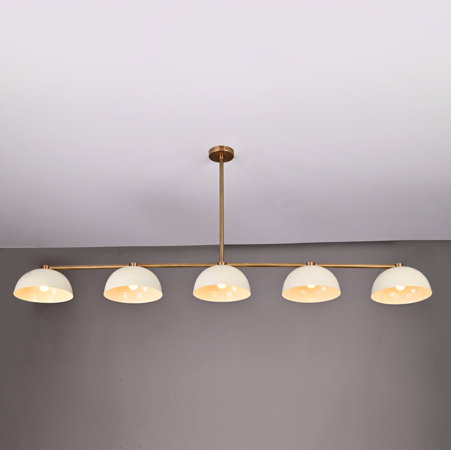 Front view of 72-inch wide, 28-inch tall linear brass chandelier with dome shades shown against a gray wall