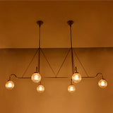Linear 6-light ribbed glass globe chandelier shown in a warm bedroom interior with brass frame and ambient ceiling lighting