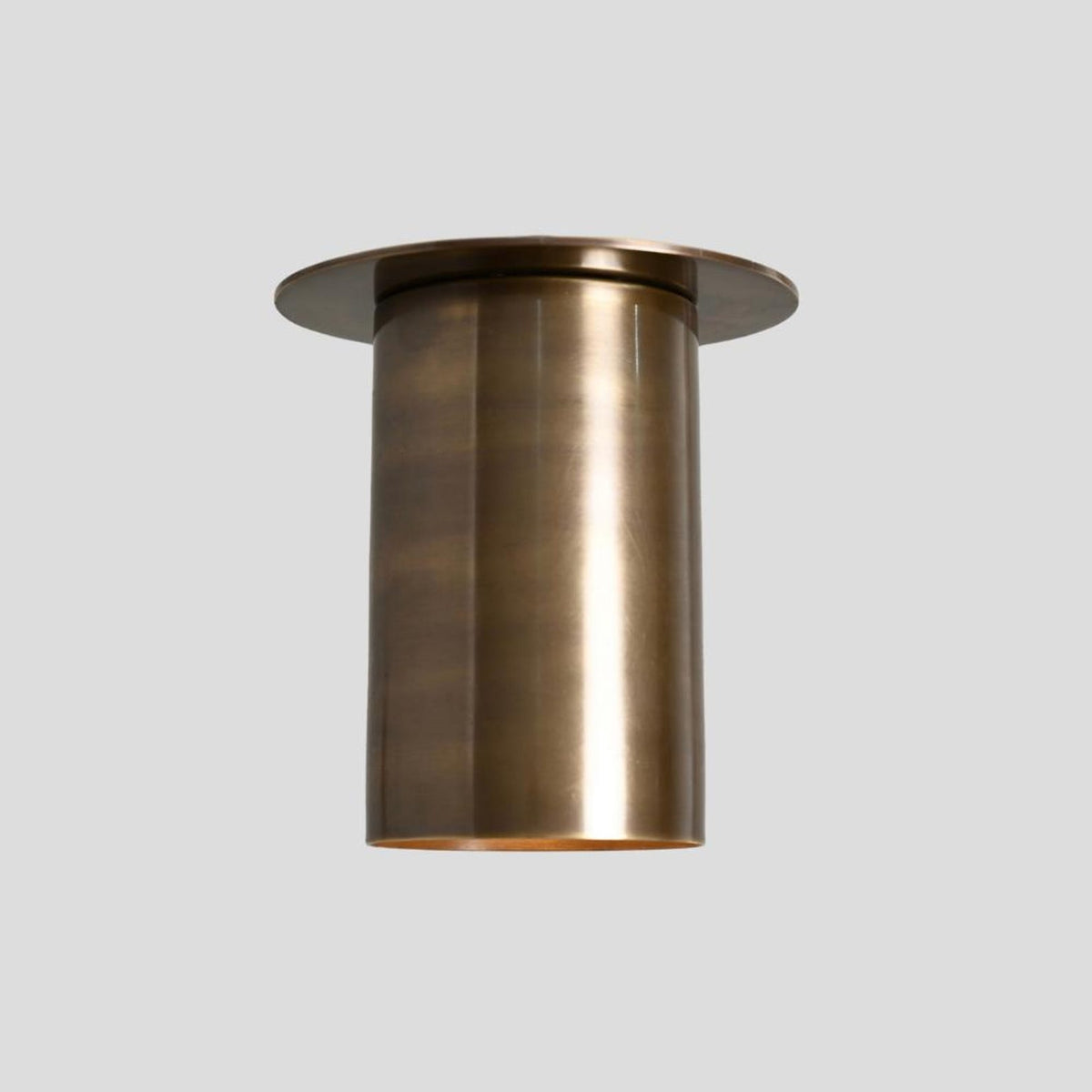 Side view of elongated brass cylinder flush mount ceiling light in brushed finish