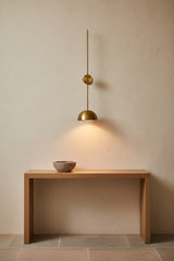 Long stem brass wall sconce with adjustable-style arm and dome bowl shade designed for statement wall lighting