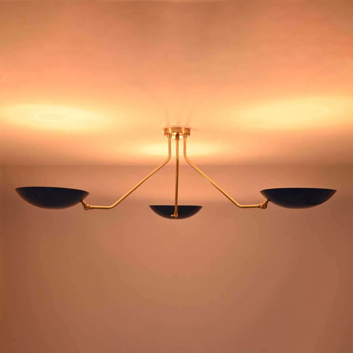 Low profile three-light brass flush mount ceiling fixture ideal for modern interiors