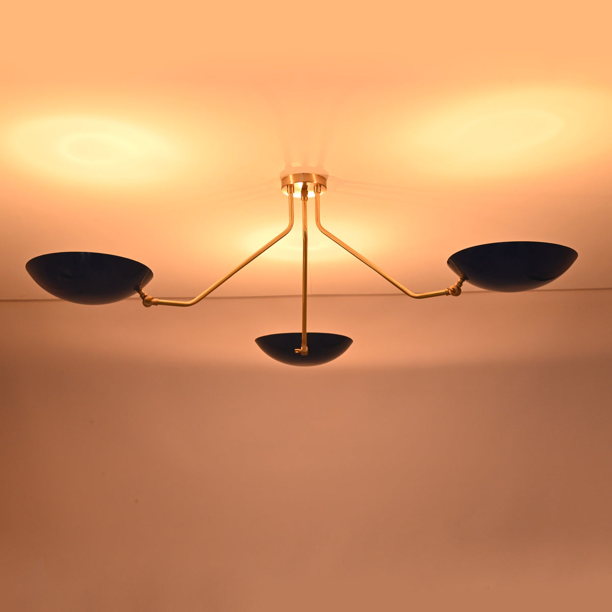 Luxury handcrafted brass flush mount ceiling light casting a warm evening glow across the ceiling