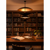 Six tier brass chandelier installed in a luxury hallway with layered blackened brass discs and elegant ambient lighting
