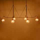 Luxury linear glass globe chandelier installed in a hotel-style lounge with warm lighting and elegant interior décor