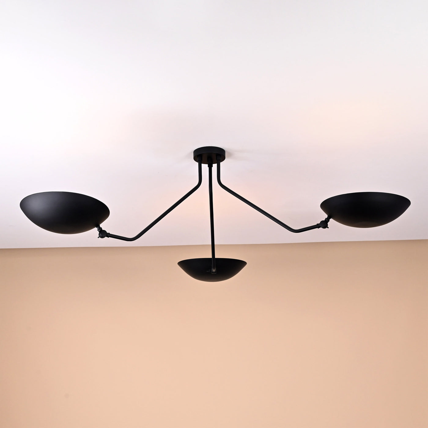 Modern minimalist ceiling light with three bowl-shaped brass shades in matte black finish for elegant interiors