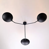 Overhead view of handcrafted matte black brass ceiling light with symmetrical three-arm layout by Brass Leaf Studio