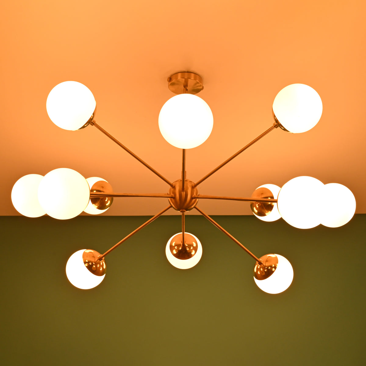 Mid century brass chandelier casting soft ceiling glow with opal glass globe shades
