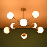 Mid century brass chandelier casting soft ceiling glow with opal glass globe shades
