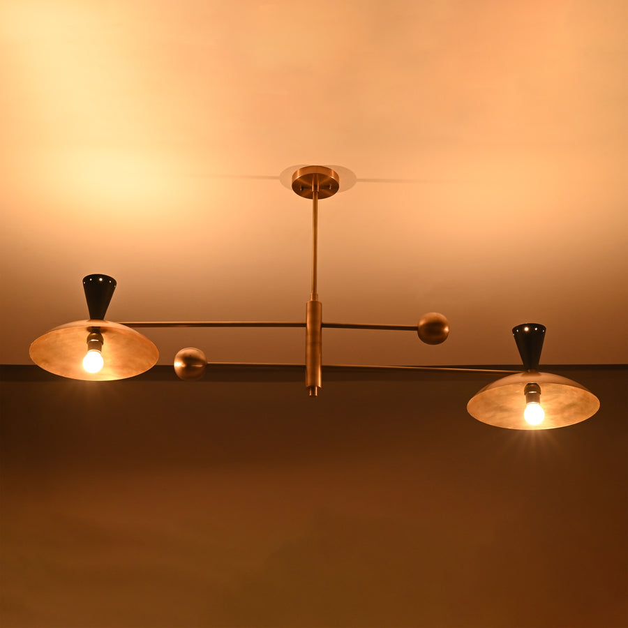 Front view of handcrafted 4-light Diabolo brass chandelier with brushed brass shades and contrasting black cone sockets.