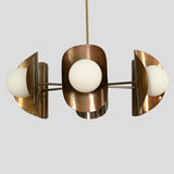Mid-century modern style brass chandelier featuring three frosted globe bulbs with industrial bowl-shaped shades.