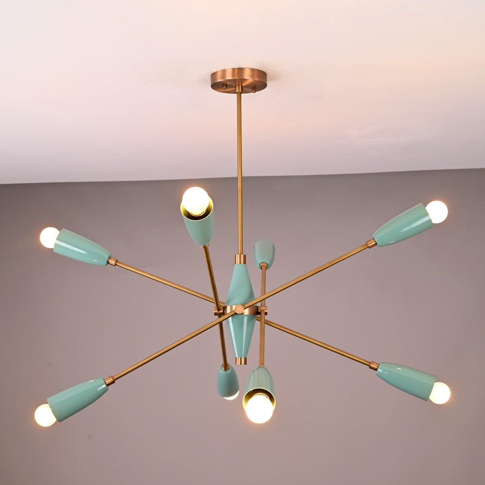 Mid-century modern Sputnik chandelier with teal light shades, brass arms, and warm bulbs illuminated against a neutral ceiling background