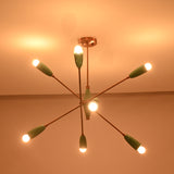 Mid century style sputnik chandelier in mint green finish with brass structure and warm glowing bulbs.