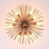 Top view of mid century starburst brass chandelier with radiant rods and warm glowing bulbs