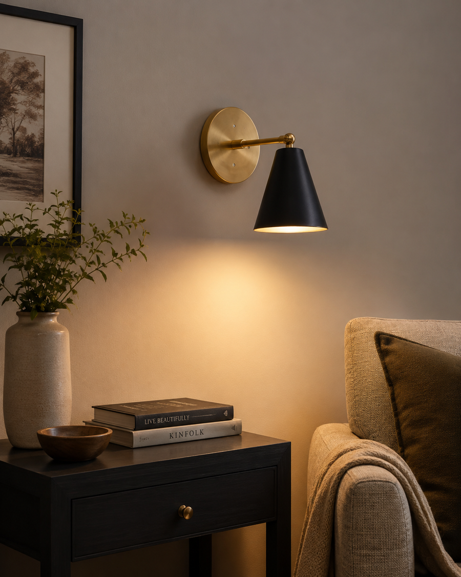 Milan adjustable black cone wall sconce installed beside seating area in warm modern interior – Model 32750