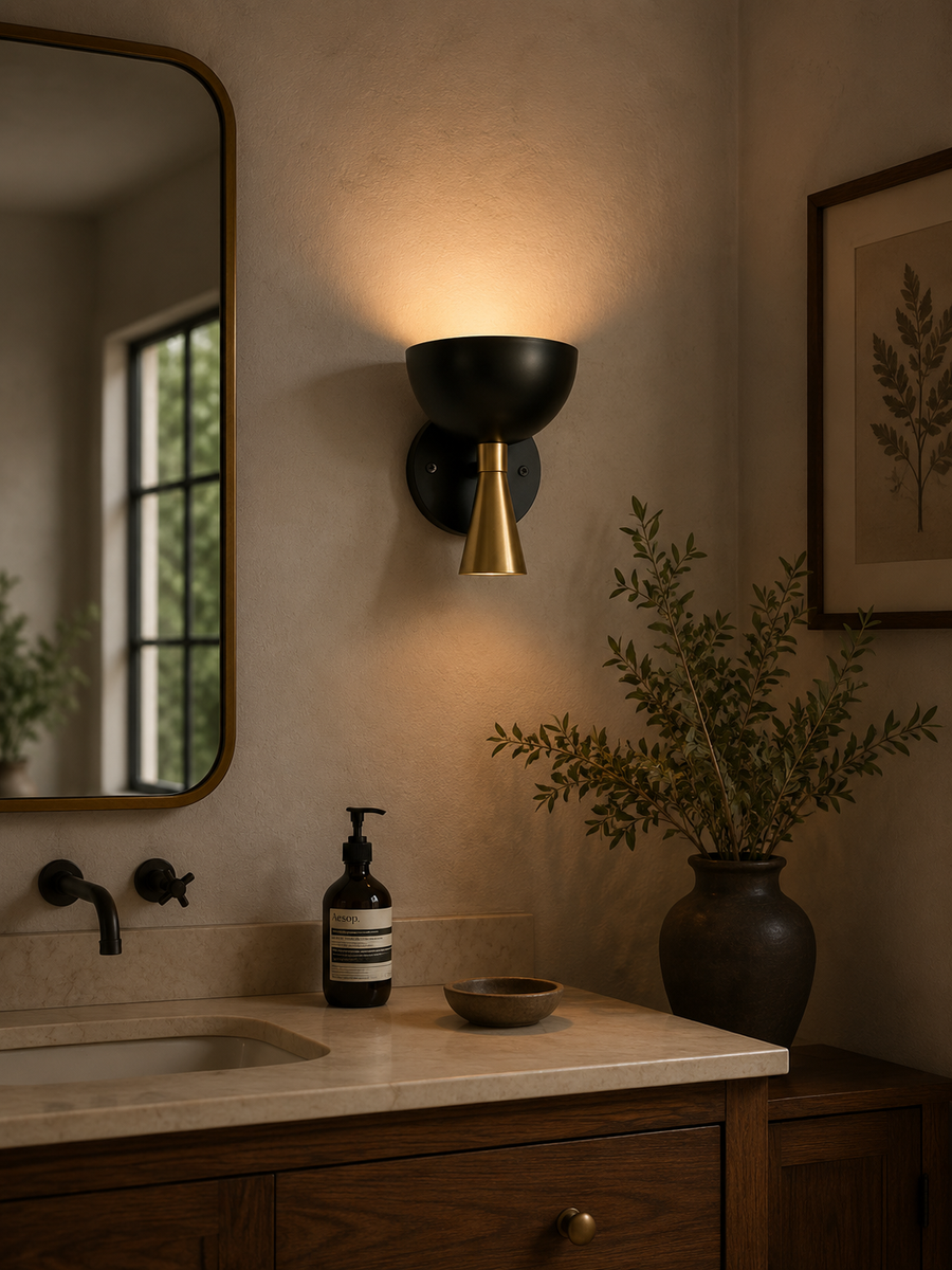 Milan black and brass dome wall sconce installed above bathroom vanity with warm ambient lighting – Model 32797