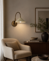 Milan curved arm cone wall sconce with brass finish styled in a modern living room – Model 32773