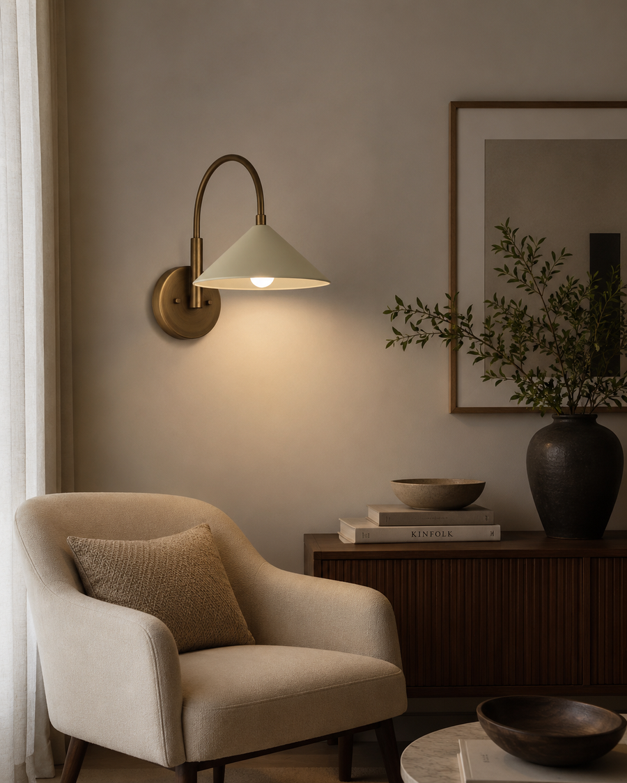 Milan curved arm cone wall sconce with brass finish styled in a modern living room – Model 32773