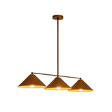 Milan Linear Cone Pendant Chandelier with three brass cone shades illuminated against white background