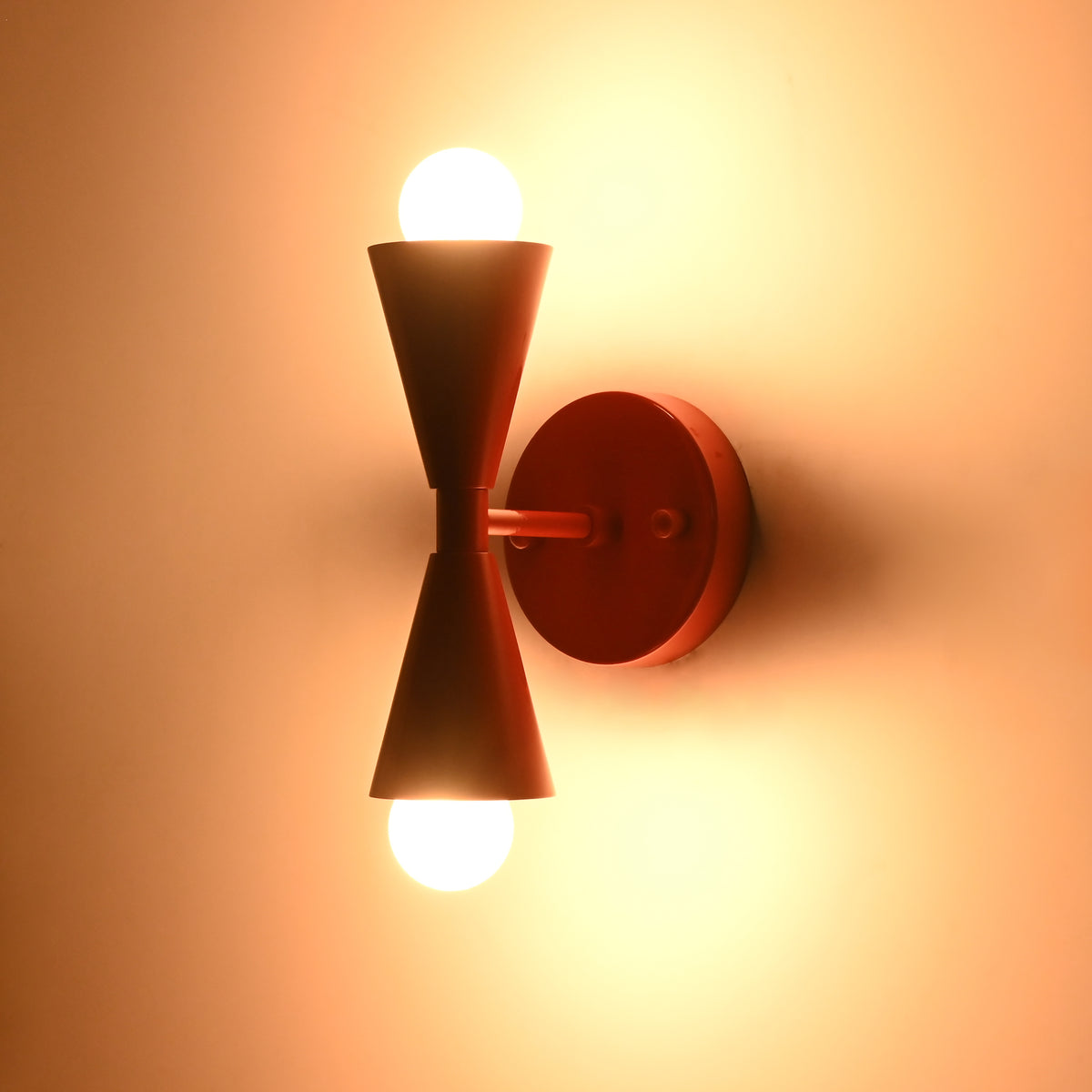 Front illuminated view of Milan Modern Double Cone Wall Sconce creating balanced upward and downward light