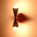 Front illuminated view of Milan Modern Double Cone Wall Sconce creating balanced upward and downward light
