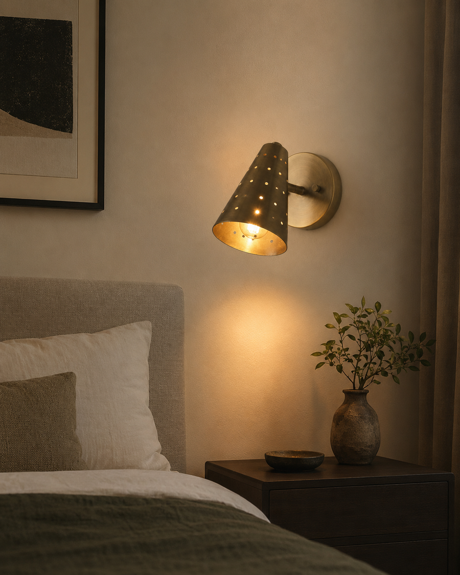 Milan perforated cone wall sconce installed beside a bed with warm ambient lighting – Model 32757