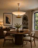 Milan 5 light white and brass chandelier displayed above a modern dining table in a warm interior setting