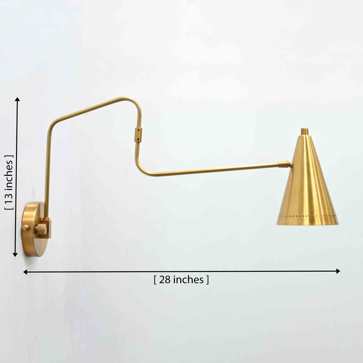 Milan raw brass swing arm wall sconce with solid brass body, long movable arm, and cone shade