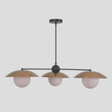 Minimalist 3-light chandelier with round globe shades and brushed brass bowl covers, designed for modern living areas and boutique spaces.