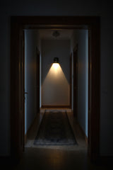 Minimalist brass bedside sconce with compact dome profile and warm downward reading or accent light