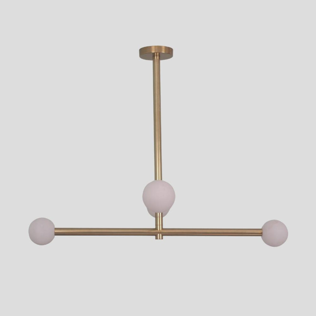 Minimalist brass linear chandelier with three frosted globe shades, modern handmade ceiling lamp.