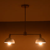 Modern brass pendant light with soft symmetrical glow from two domes