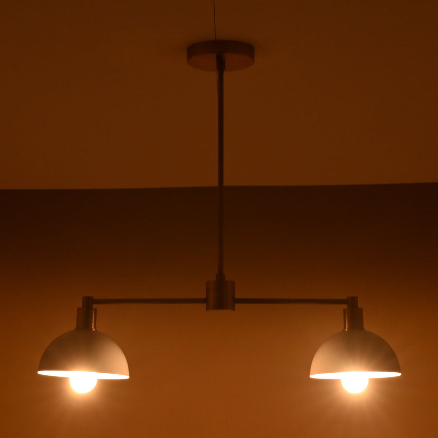 Modern two-light brass pendant with white domed shades and sleek minimalist design