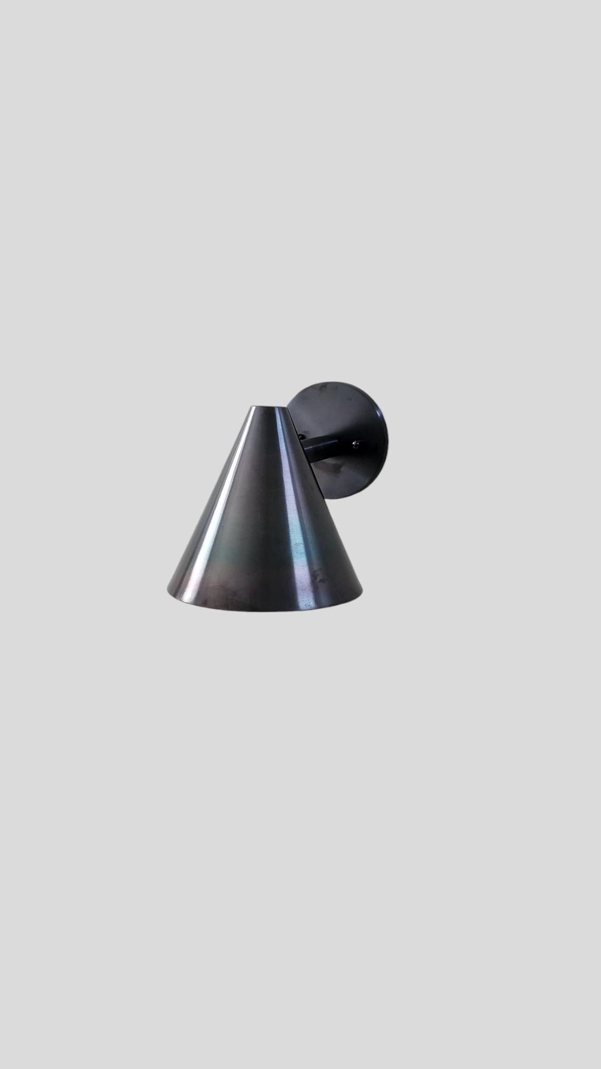 Minimalist cone-shaped wall light in blackened brass finish, ideal for modern bedrooms, cafes, and hallway lighting.