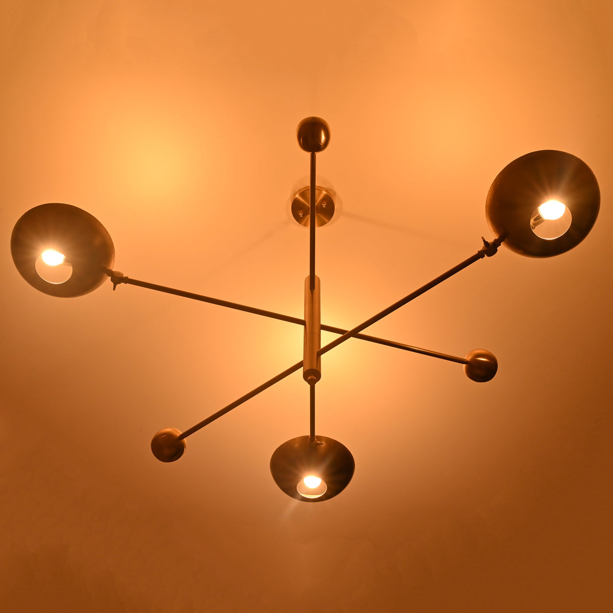 Minimalist disc brass chandelier creating moody atmospheric lighting