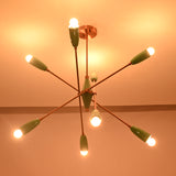 Mint green sputnik chandelier casting warm ambient light across the ceiling in a dark setting.