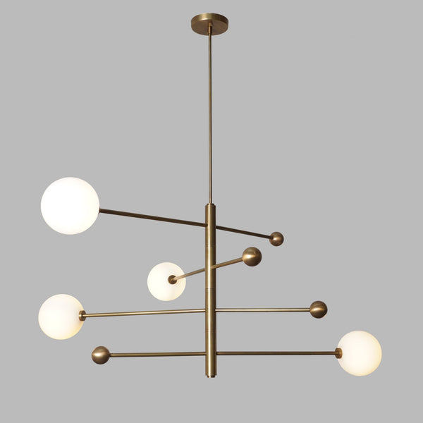 Contemporary 4 Light Brass Globe Chandelier featuring sleek brass structure and spherical white glass globes for elegant interior lighting
