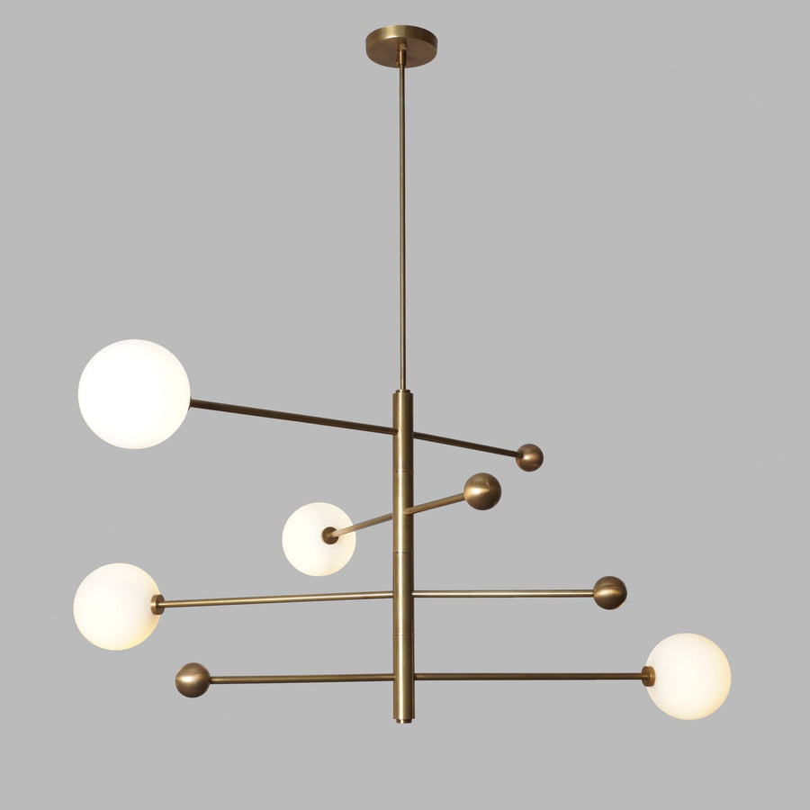 Contemporary 4 Light Brass Globe Chandelier featuring sleek brass structure and spherical white glass globes for elegant interior lighting