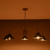 Night view of modern 5-light brass cone chandelier with perforated detailing and warm golden illumination.
