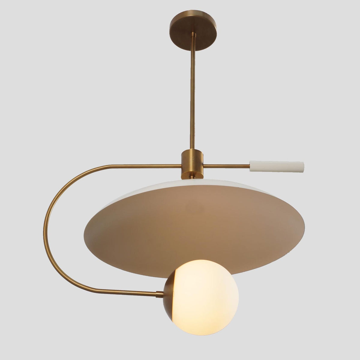 Sculptural balance chandelier crafted in brass with a large white dome and frosted globe shade, offering warm diffused illumination.