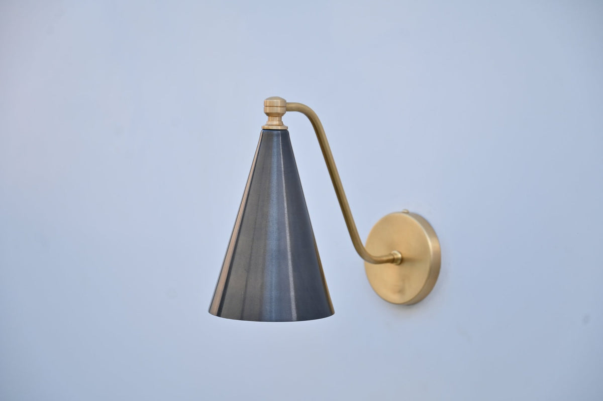 Side view of modern blackened brass cone wall sconce with brushed brass arm and circular backplate.