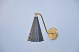 Side view of modern blackened brass cone wall sconce with brushed brass arm and circular backplate.