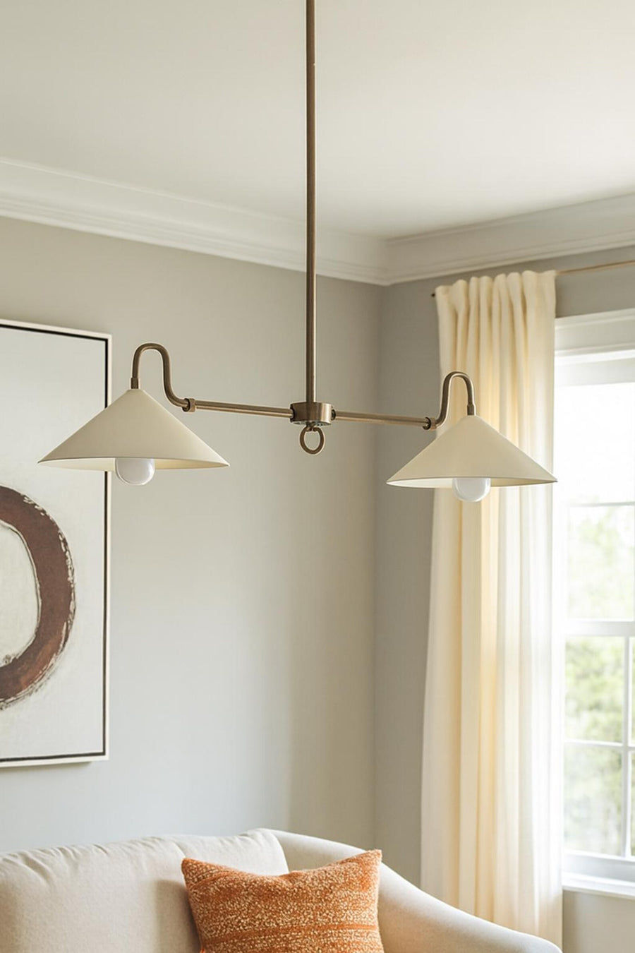 Mid-century modern 2-light cone chandelier in solid brass hanging above a dining table with warm ambient lighting