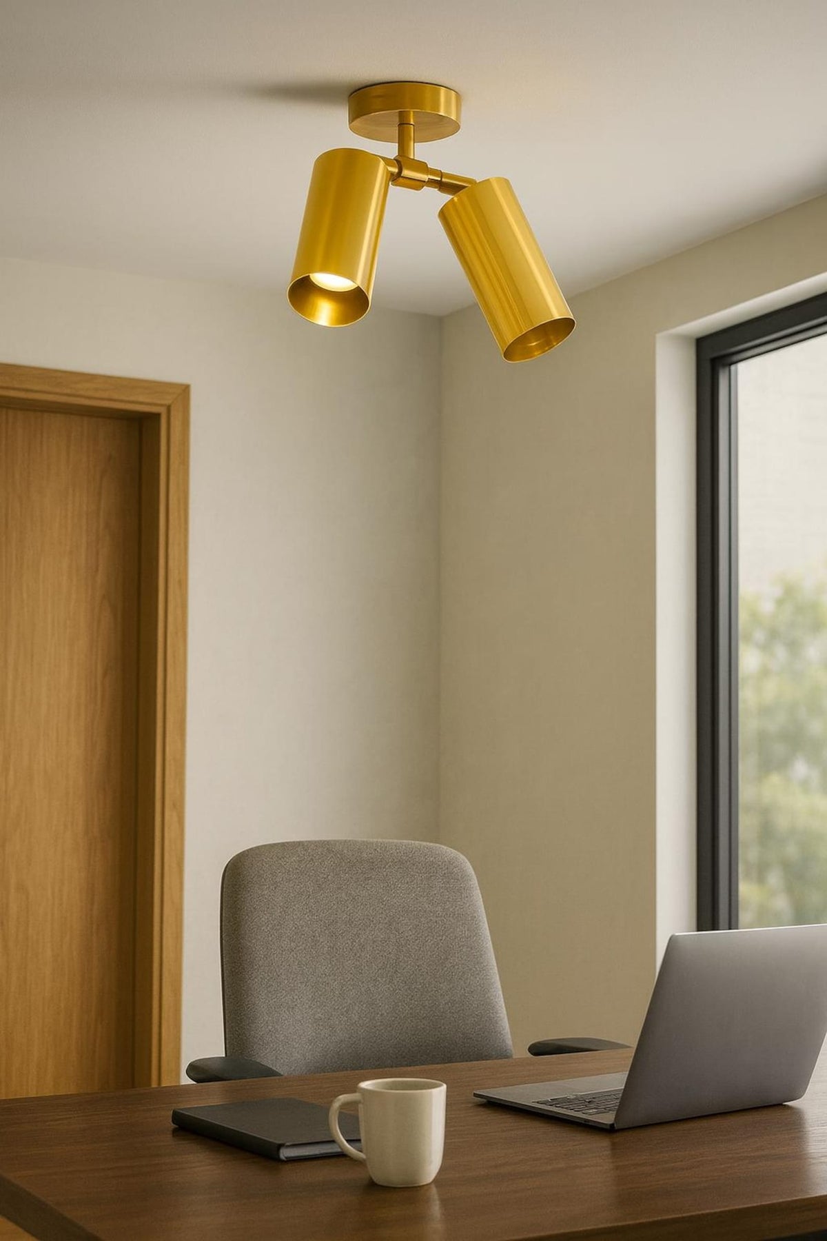 Modern 2-light brass flush mount ceiling spotlight installed in home office above desk and laptop workspace.